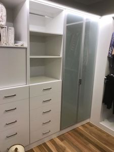 Built-In-Wardrobe-Standard-White-Board-Shelving-with-Chrome-Hanging-Rod-and-Banks-of-Drawers-with-Polished-Silver-Handles