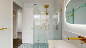 ShowerScreens_10mm_Hinged_Corner_GoldHardware_HeaderBrace_StroudHomesBrisEast3