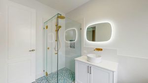 ShowerScreens_10mm_Hinged_Corner_GoldHardware_HeaderBrace_StroudHomesBrisEast2
