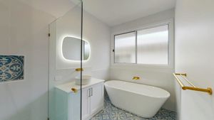 ShowerScreens_10mm_Hinged_Corner_GoldHardware_HeaderBrace_StroudHomesBrisEast